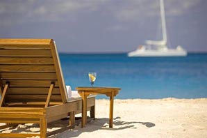 chair on the beach with sailboat in water