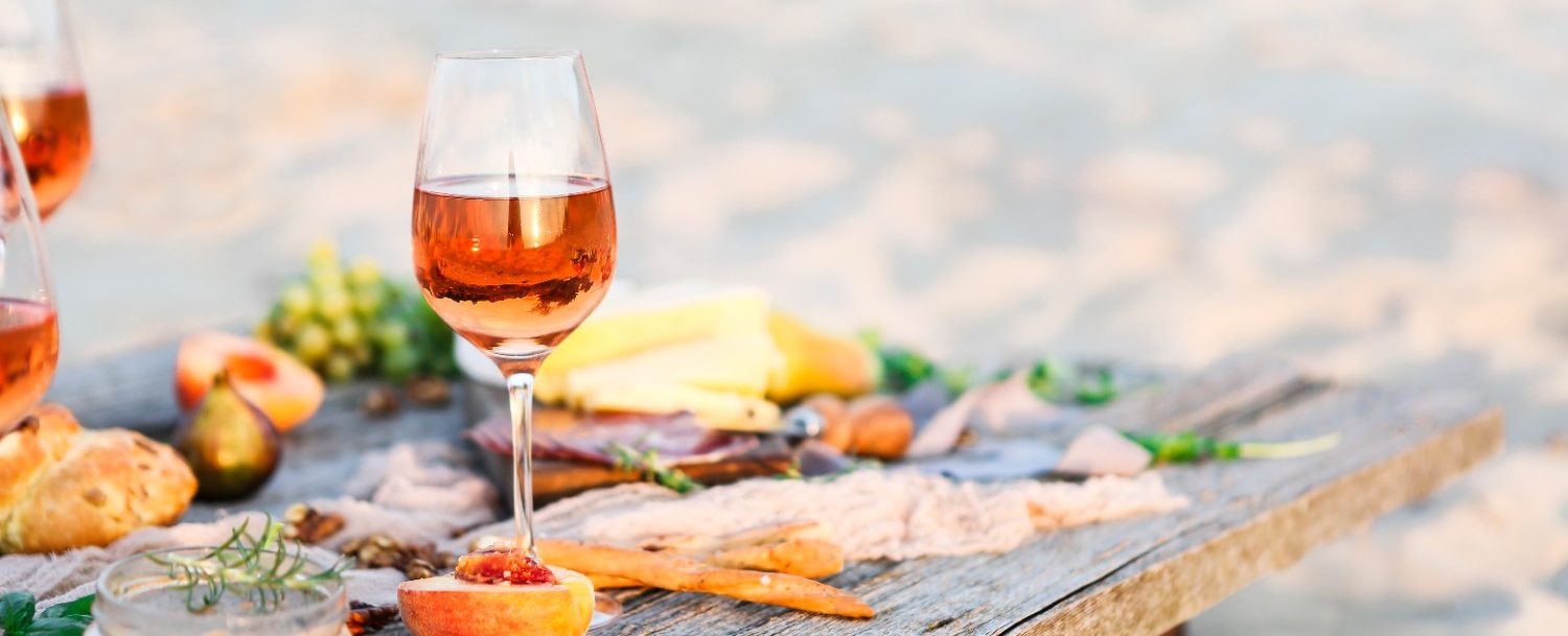 Glass of rose wine on rustic table. Food and drink background