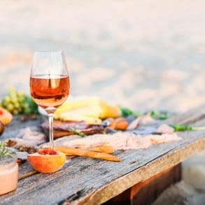 Glass of rose wine on rustic table. Food and drink background