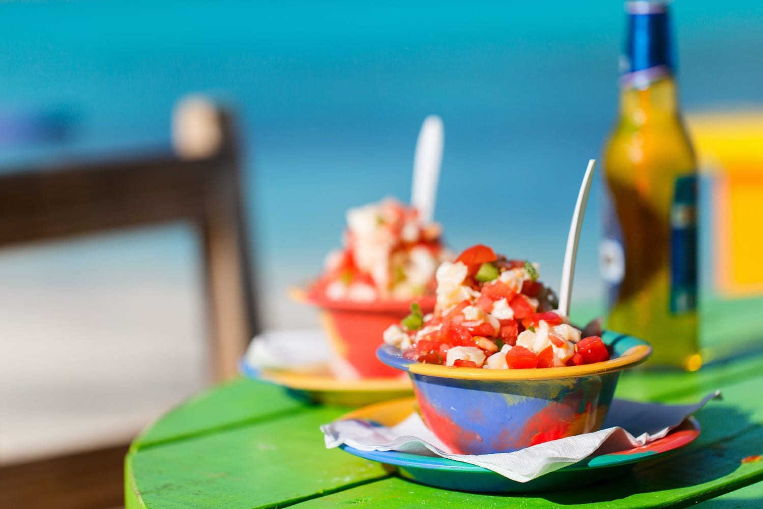 Two bowls of Bahamian conch salad and bottle of beer