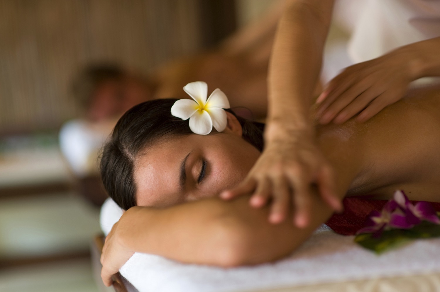 A young woman having massage in tropical spa