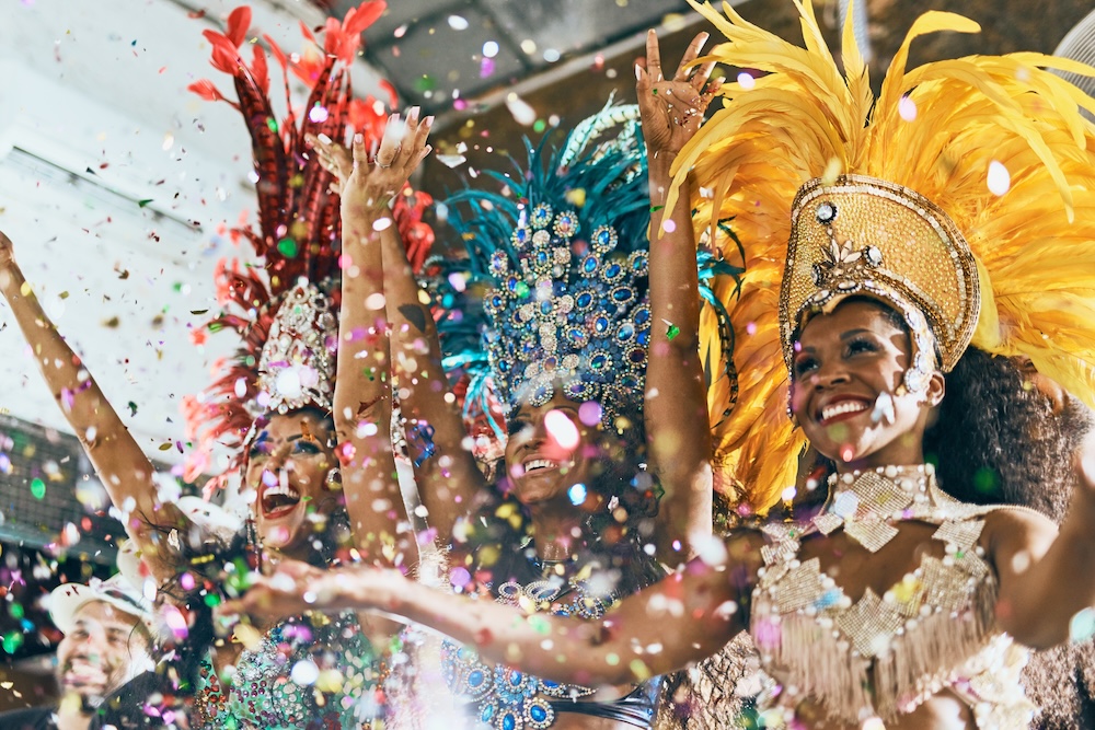 Cropped shot of beautiful samba dancers performing in a carnival with their band.
