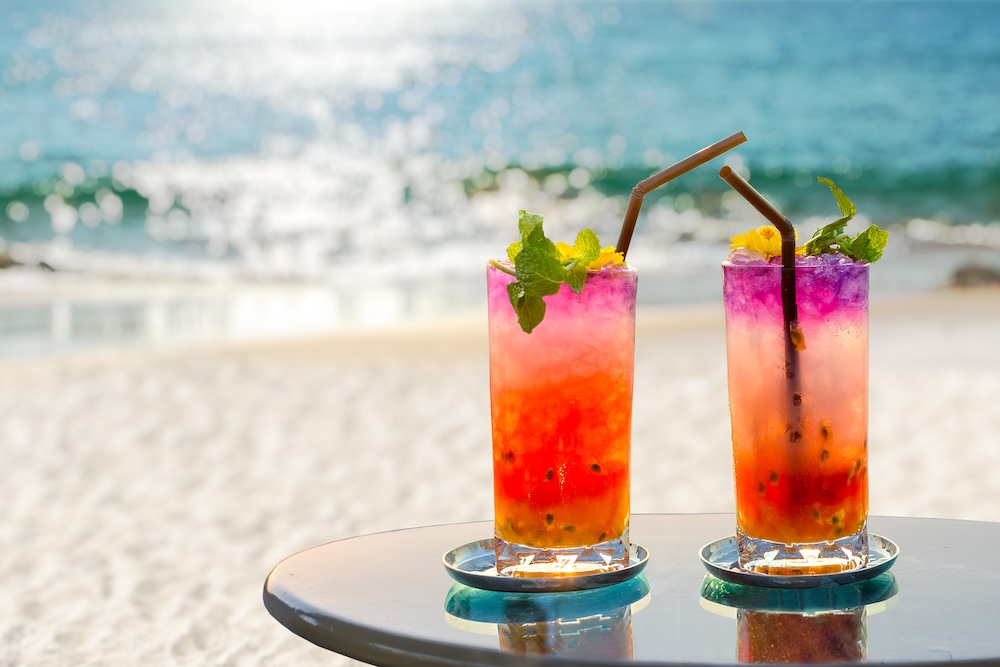 Two colorful cocktails on the beach.