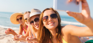 Group of young women taking selfie at the beach