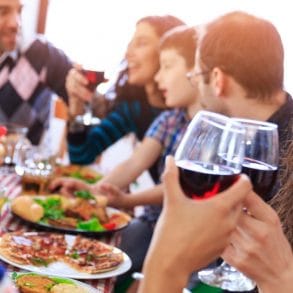 People feasting and drinking wine outdoors